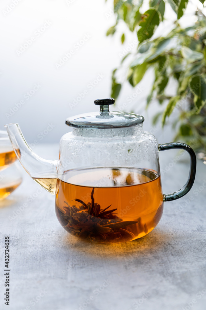 Chinese flower tea brewed in a transparent teapot with two cups . Vertical format Chinese flower tea brewed in a transparent teapot with two cups . Vertical format