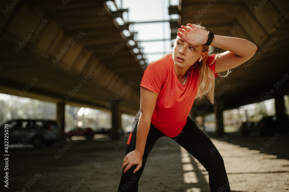 Close up photo of attractive female runner taking break after jogging outdoors. Close up photo of attractive female runner taking break after jogging outdoors.
