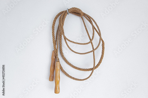 A old skipping rope hanging on a white wall. photo