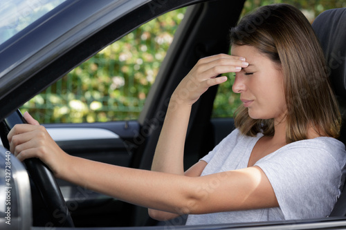 young female driver with headache in a car © auremar