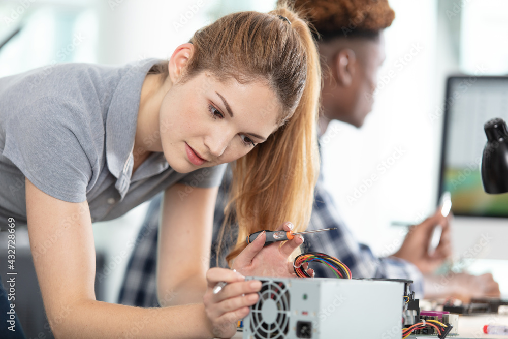 woman fixing a computer at workshop