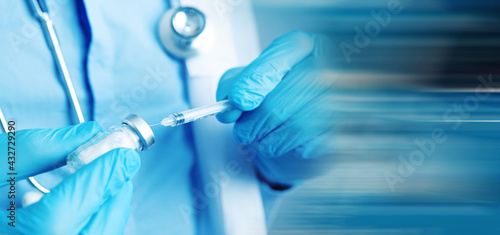 Photos a doctor holding a syringe ready to give a vaccine injection