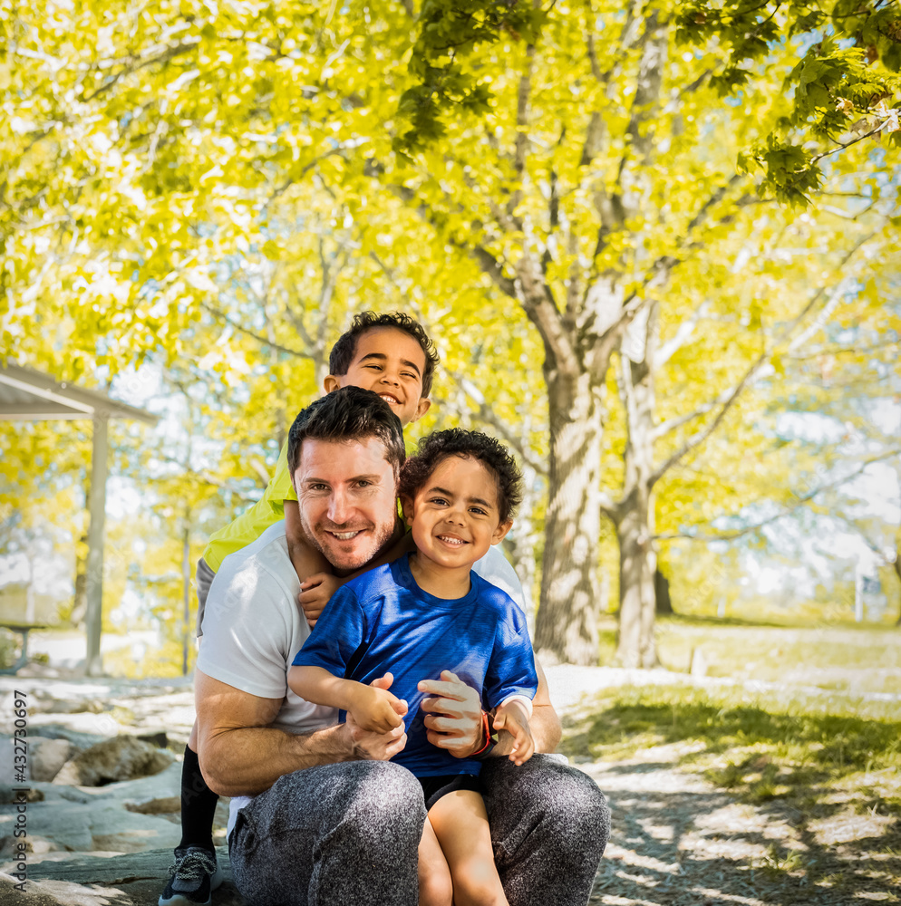 Portrait of white father and his African-American twin boys in park on nice spring day in Missouri Portrait of white father and his African-American twin boys in park on nice spring day in Missouri
