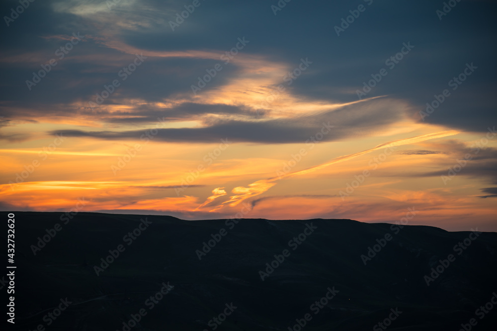 Colorful sunset over the mountain hills. Beautiful clouds flying over the lake near mountains. Evening time shot over the clouds. Baku, Azerbaijan.