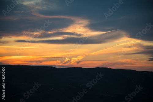 Colorful sunset over the mountain hills. Beautiful clouds flying over the lake near mountains. Evening time shot over the clouds. Baku, Azerbaijan. © zef art