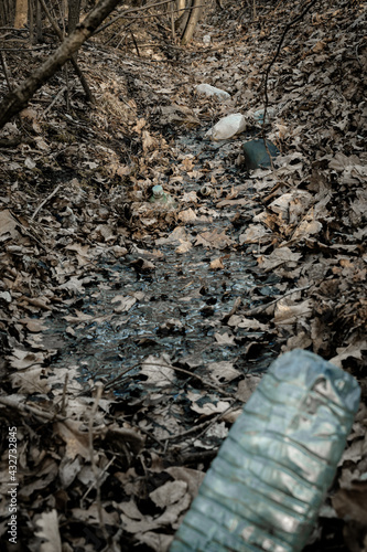 Environmental concept. Forest with trash  plastic rubbish. garbage waste in environment woodland. Ecological problem with Empty used dirty plastic bottles.