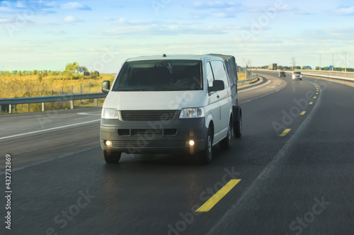 minivan with trailer moves along road