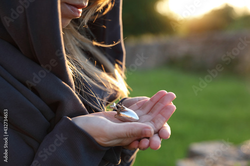 Woman holding heart shaped amulet necklace. Follow your heart. Emotional Vulnerability concept photo