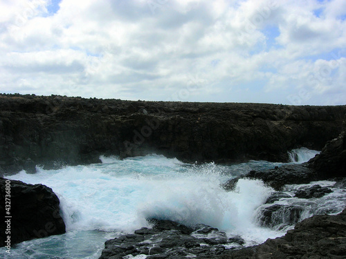 Splashes and waterfalls left by the breaking wave on the rocks of the cave of the blue eye of Barracona  natural pool  Sal Island  Cape Verde