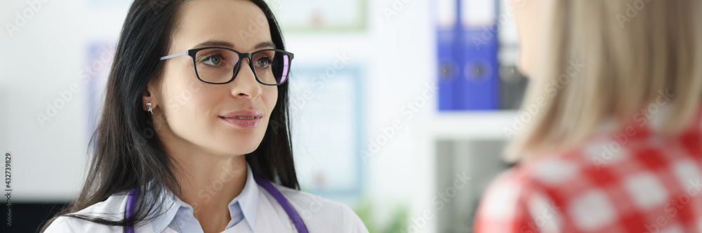 Female doctor communicating with patient in clinic Female doctor communicating with patient in clinic