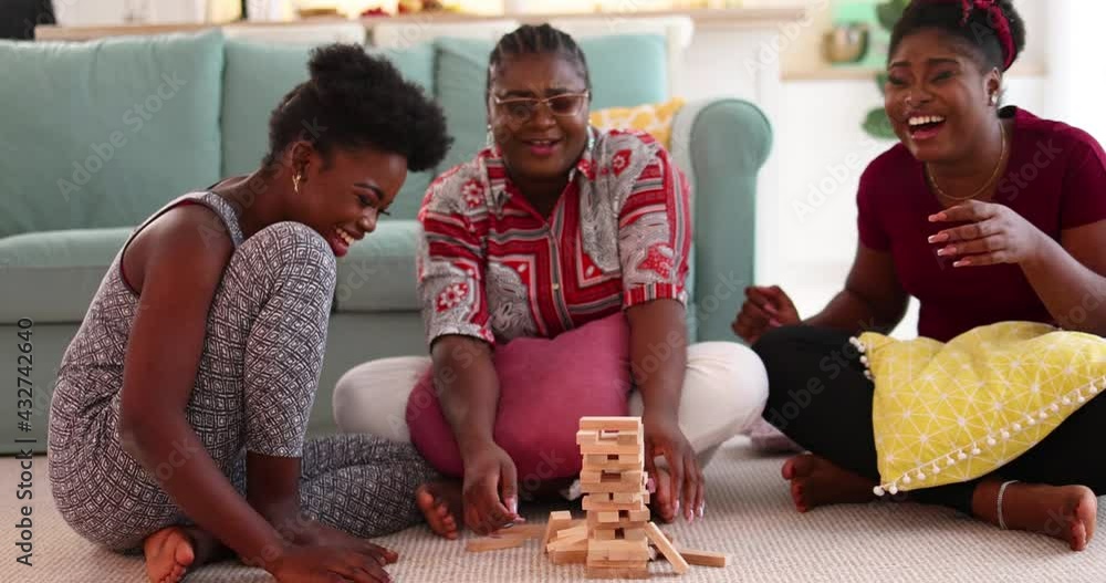 wooden block tower falling down, laughing friends playing game at home