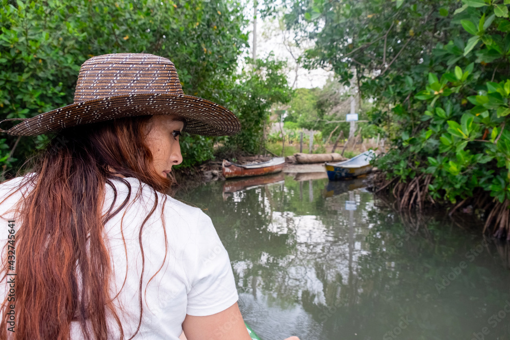 woman with hat navigating a mangrove