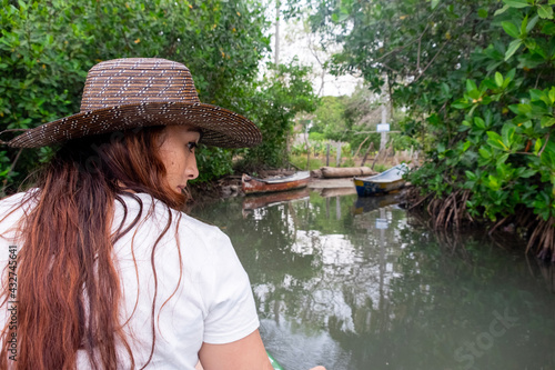 Obraz na płótnie woman with hat navigating a mangrove w salonie