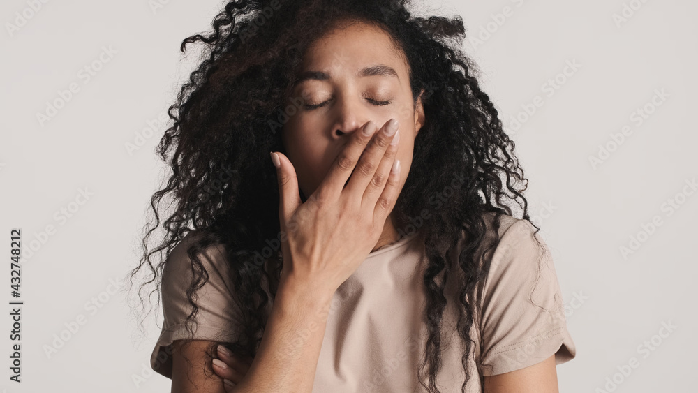 Tired African American woman with fluffy hair yawning want to sl Tired African American woman with fluffy hair yawning want to sl
