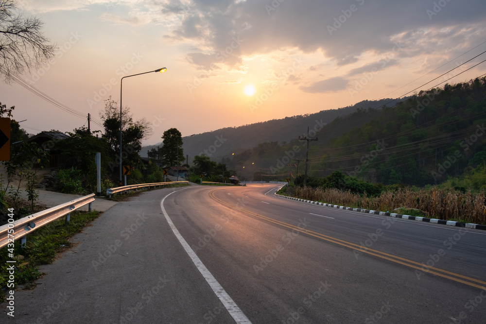 Paved road curve on mountains.Road dividing line.The road to the mountain in sunset time.