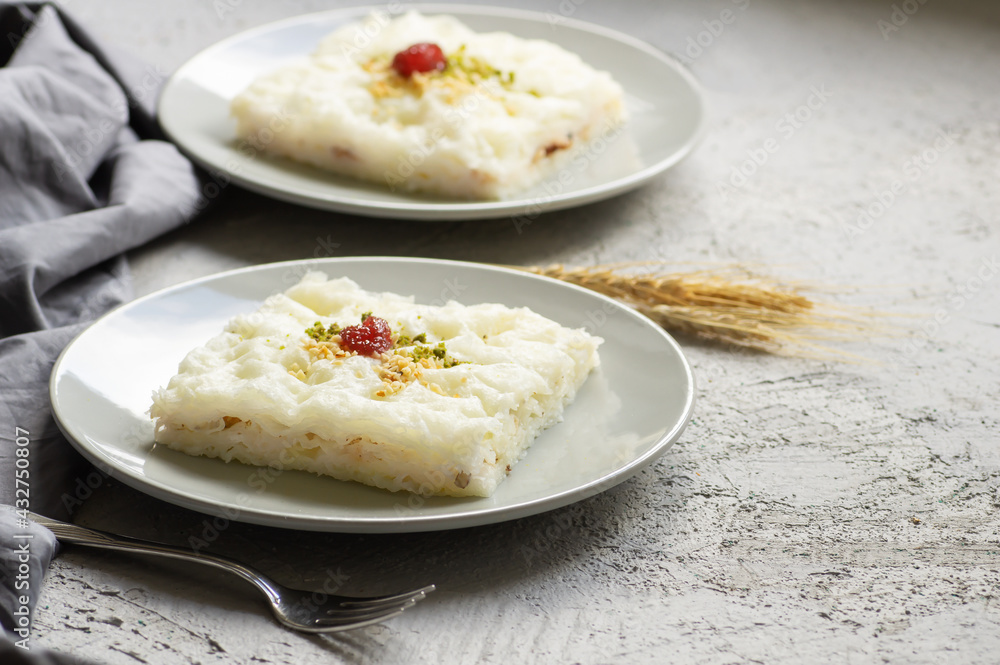 Traditional Turkish Ramadan dessert gullac, milky dessert with pistachio powder and strawberry jam, ottoman cuisine