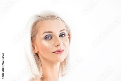 portrait of a beautiful young blonde woman with short hair on a white background. She has a clear  glowing skin  like after care. Light makeup