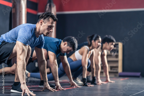Group of multiethnic athlete doing exercise by mountain climbers pose.
