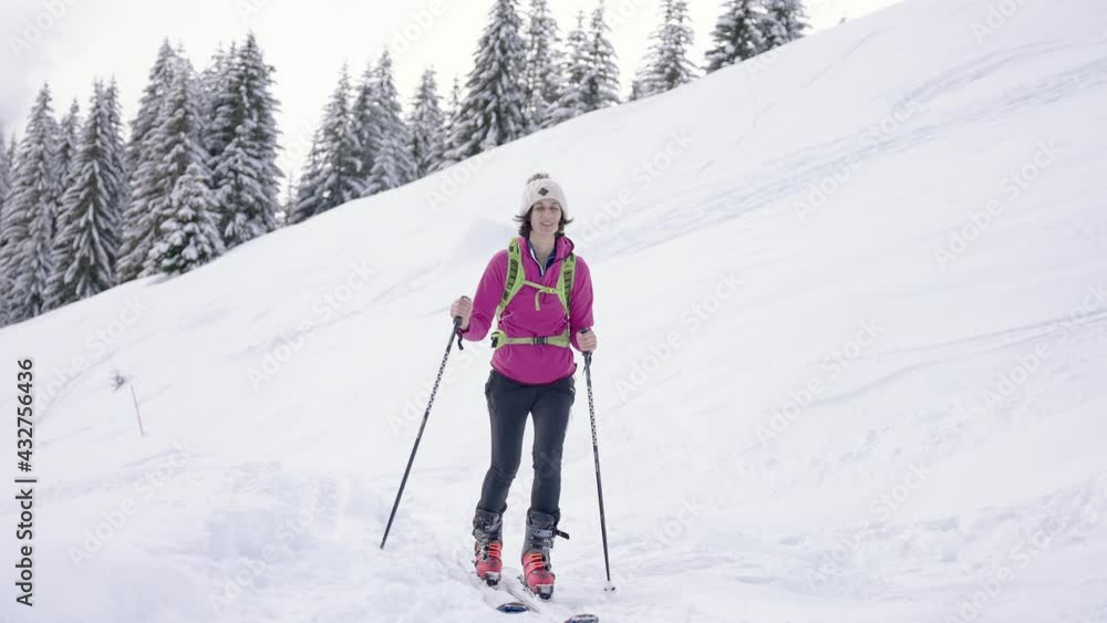 Young athletic woman walking downhill snow slope in skiing gear Young athletic woman walking downhill snow slope in skiing gear