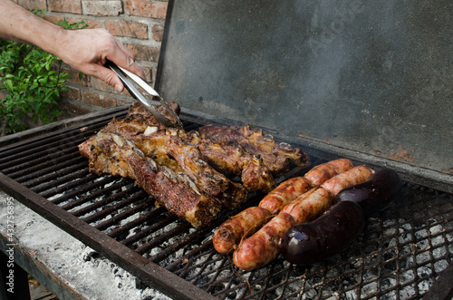 Man hand cooking a delicious Argentinian barbecue on a coal grill.