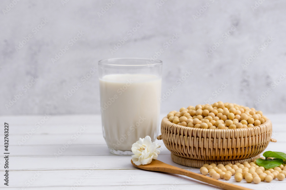 Soy and soy milk in a glass with soybeans in wooden bowl background Soy and soy milk in a glass with soybeans in wooden bowl background