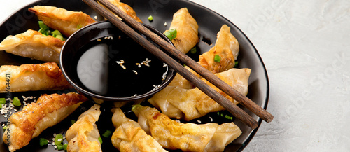Foto Fried gyoza dumplings with soy sauce and onion on light gray background
