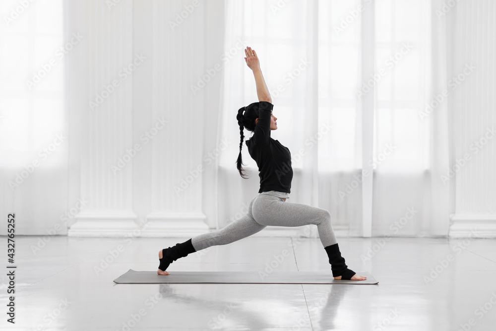 Cobra Pose. Beautiful young asian woman practicing yoga pose on gray mat at yoga studio