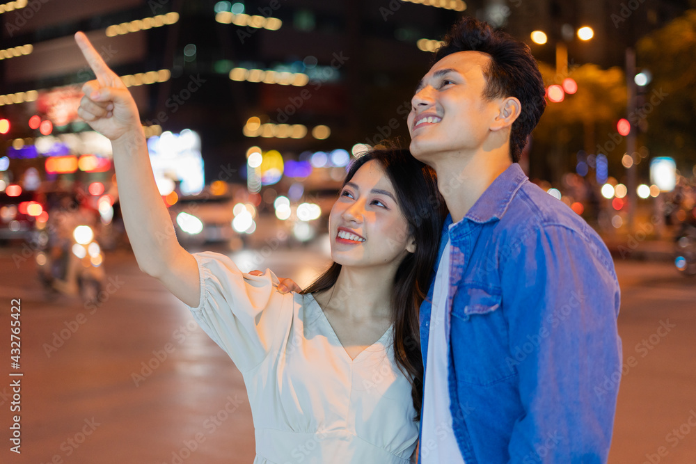 Young Asian couple walking on the street at night