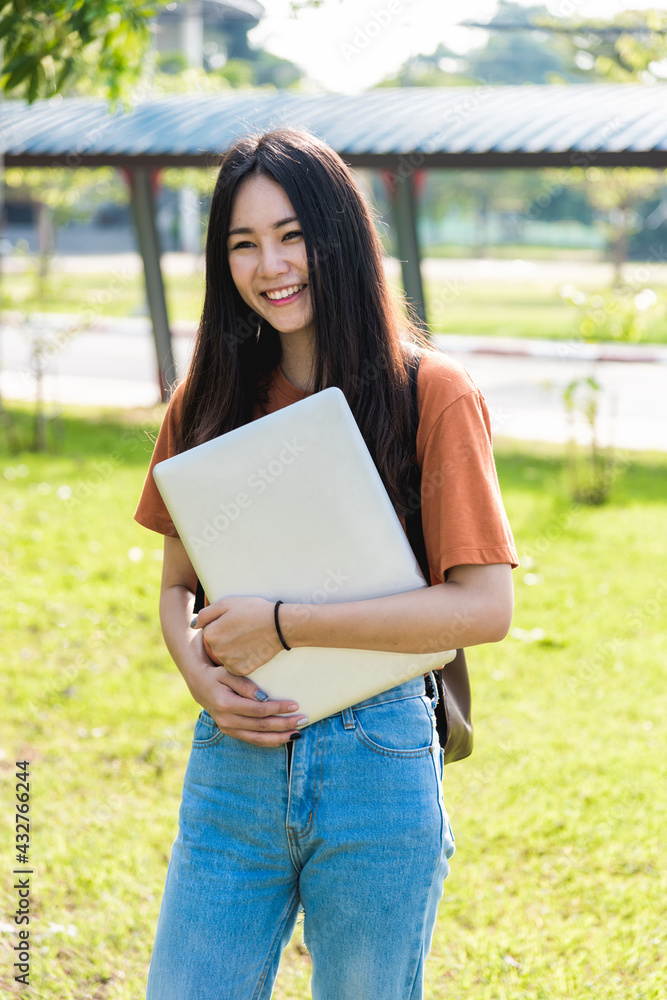 Fototapeta premium Young woman with backpack hold notebook standing in university