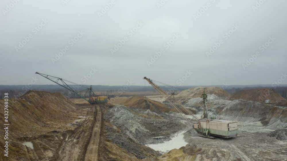 Aerial view of quarry with equipment. Quarry mine industry rock extraction heavy machinery equipment. Dragline Excavator Loads Soil, Clay. Dragline excavator in surface mine area with landscape. 