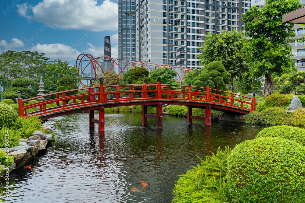 Beautiful Japanese garden with a red bridge crossing the Koi fish pond Beautiful Japanese garden with a red bridge crossing the Koi fish pond