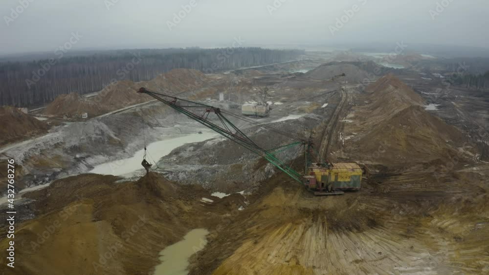 Aerial view of quarry with equipment. Quarry mine industry rock extraction heavy machinery equipment. Dragline Excavator Loads Soil, Clay. Dragline excavator in surface mine area with landscape. Aerial view of quarry with equipment. Quarry mine industry rock extraction heavy machinery equipment. Dragline Excavator Loads Soil, Clay. Dragline excavator in surface mine area with landscape.