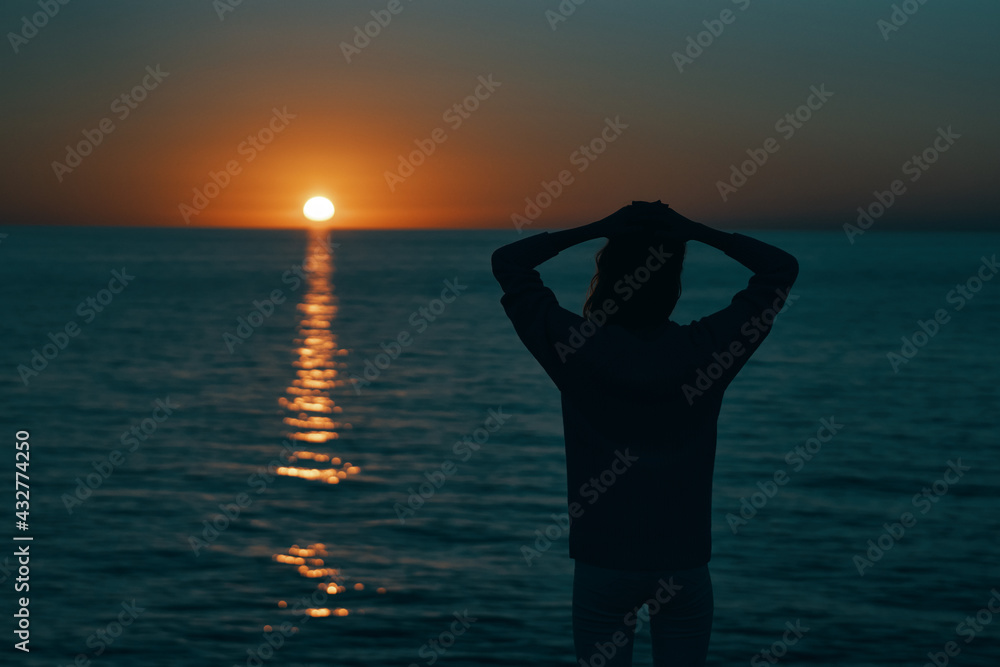 Fototapeta premium female silhouette on the beach near the sea at sunset