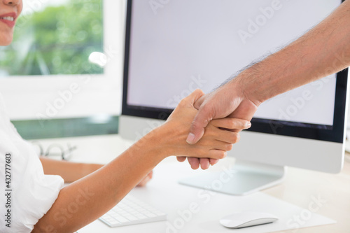 Two businesspersons fist-bumping in agreement at a meeting at office