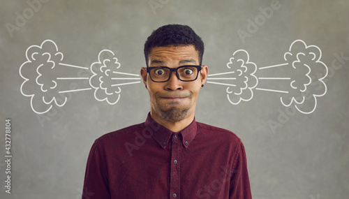 Headshot funny crazy tired annoyed black man trying to control emotions. Head shot peeved big eyed manager, employee, worker, student or client looking at camera with steam or smoke coming out of ears