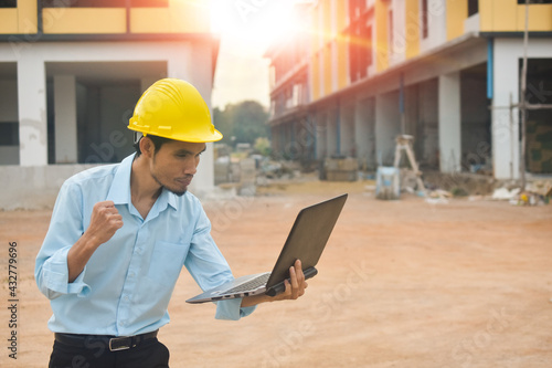 Worker holding computer working building construction site