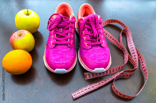   apples, meter tape, pink sneakers.  Fitness accessories. Measuring tape, centimeter.  The concept of joint sports, Healthy way of life.