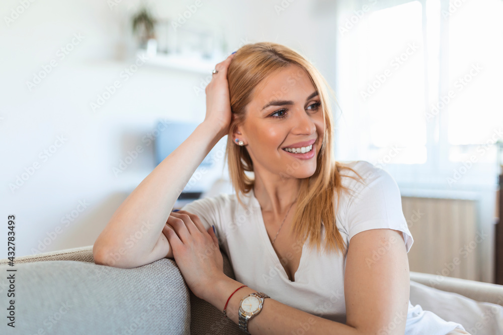 Portrait of a girl relaxing on a sofa after work at home sitting on a sofa in the living room at home with a warm light of sunset Portrait of a girl relaxing on a sofa after work at home sitting on a sofa in the living room at home with a warm light of sunset
