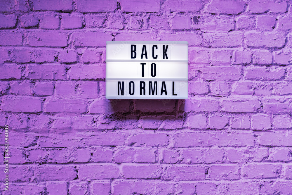 Fototapeta premium Text Back to normal in lightbox on brick wall