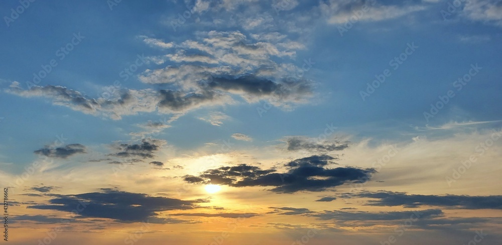 Beautiful golden sunset background in blue sky 