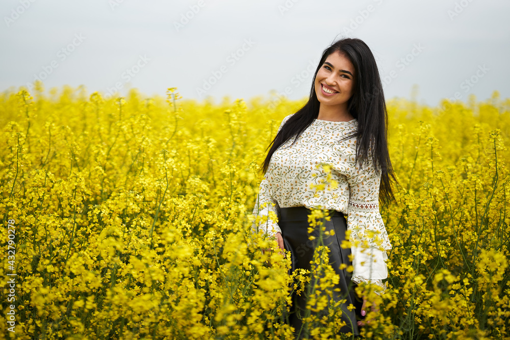 Hispanic woman in a canola field Hispanic woman in a canola field