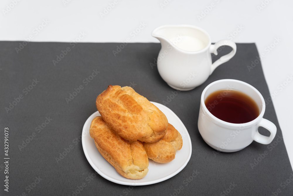 Homemade delicate profiteroles on table, cup of coffee. Traditional French eclairs. Top view Homemade delicate profiteroles on table, cup of coffee. Traditional French eclairs. Top view