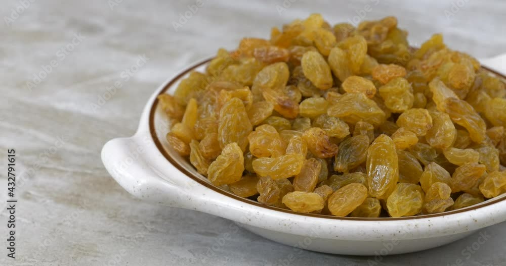 Bowl of golden raisins sliding into view on a kitchen counter Bowl of golden raisins sliding into view on a kitchen counter