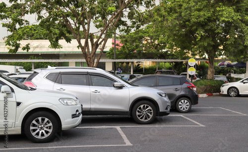 Closeup of front side of white car with  other cars parking in outdoor parking area. © Amphon