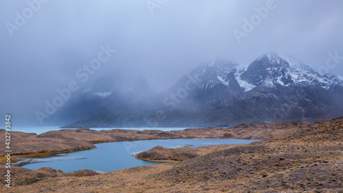 Landscape in Torres del Paine national park, chile with lakes and mountains disappearing in the fog