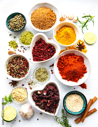 Various spices in a bowls on white background. Top view copy space.