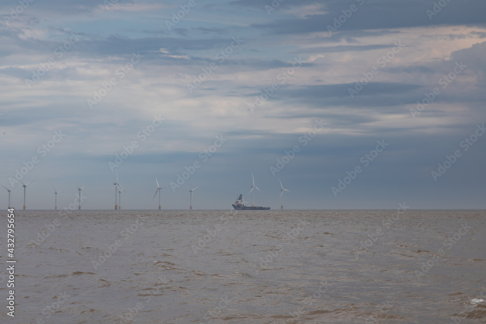 Turbines on the horizon with a shipping vessel