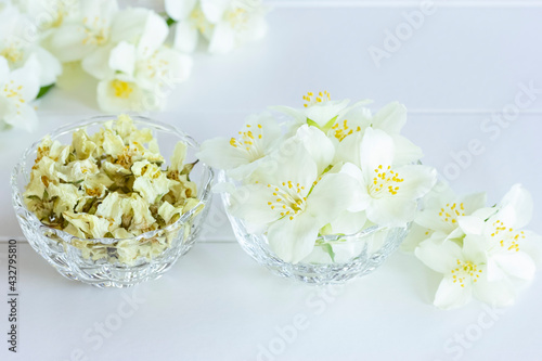 jasmine flowers in a glass bowl close-up. jasmine as an element for making tea. background with white jasmine flowers.