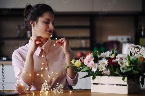 Beautiful portrait of woman with lights and flowers. Holiday celebration concept. Valentine s Day  Woman s day. Creative florist