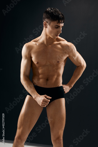man with muscular body posing in dark panties